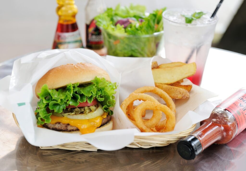 A hamburger and onion rings on a table