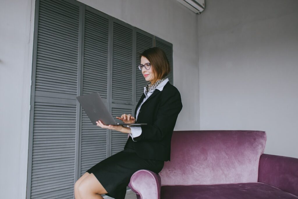 a woman sitting on a couch using a laptop computer